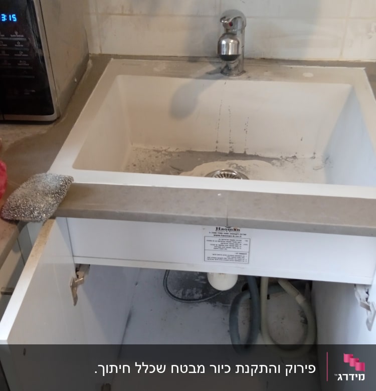 כיור עם ברז, צינורות מתחת לארון פתוח